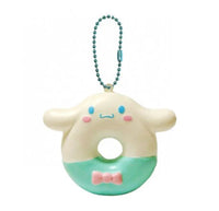 "Cinnamoroll-themed squishies including a donut, cake slice, cream puff, and waffle, each designed with pastel colors and cute character details. Packaged in original Sanrio 2017 packaging, showcasing the soft, textured surface and collectible charm."