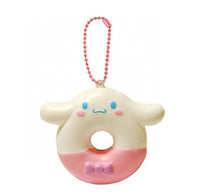 "Cinnamoroll-themed squishies including a donut, cake slice, cream puff, and waffle, each designed with pastel colors and cute character details. Packaged in original Sanrio 2017 packaging, showcasing the soft, textured surface and collectible charm."