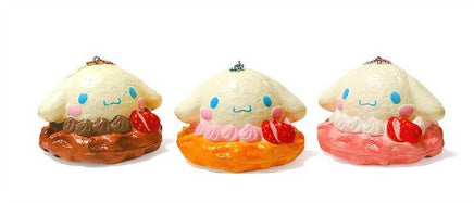 "Cinnamoroll-themed squishies including a donut, cake slice, cream puff, and waffle, each designed with pastel colors and cute character details. Packaged in original Sanrio 2017 packaging, showcasing the soft, textured surface and collectible charm."