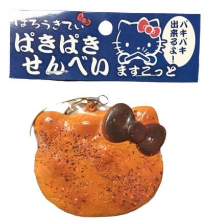 RARE Hello Kitty Paki Paki rice cracking squishy designed to resemble a traditional Japanese senbei rice cracker, featuring Hello Kitty branding; Sanrio-licensed vintage item from 1976–2010, with possible age-related cracks or imperfections.