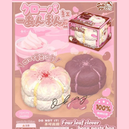 Four Leaf Clover Bean Paste Bun Squishy in white featuring realistic bakery texture, scented slow-rising foam, displayed in a clear protective collector box for kawaii décor and stress relief.