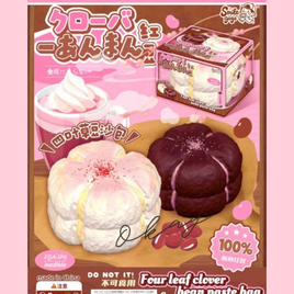 Four Leaf Clover Bean Paste Bun Squishy in white featuring realistic bakery texture, scented slow-rising foam, displayed in a clear protective collector box for kawaii décor and stress relief.