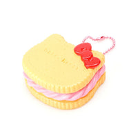RARE Hello Kitty Sweets Cafe Rusk Biscuit Squishy featuring a golden brown biscuit design with embossed Hello Kitty details, attached pink ball chain, and red Sanrio authenticity sticker; vintage item from 1976–2010, not slow rising, shown in original condition.