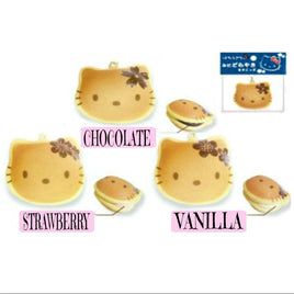 Sanrio Hello Kitty RARE Dorayaki squishy featuring Hello Kitty's face nestled between two pancake-style buns. The squishy has a soft, round shape with realistic bread texture, packaged in original licensed packaging with a red authenticity sticker. A vintage collectible produced between 1976 and 2010.